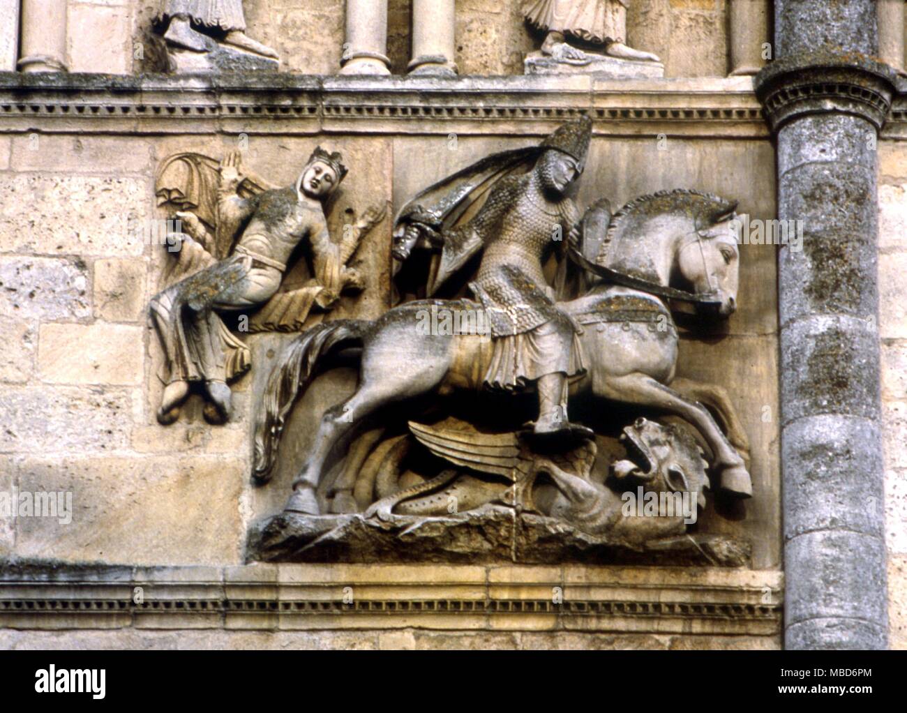 DRAGON - St George and the Dragon - Nineteenth century restoration of an earlier rider (of unknown meaning) in the guise of St George and the Dragon, with the princess in the background. Detail on the facade of Angouleme cathedral. Stock Photo
