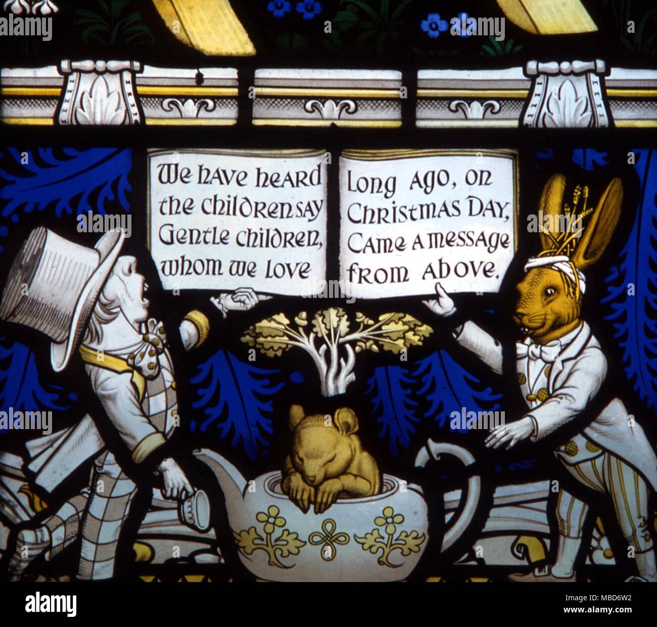 Myths - Daresbury - The Lewis Carroll memorial window at Daresbury Parish Church was designed by Geoffrey Webb, and dedicated in 1934. The Mad Hatter, the Dormouse and the March Hare. - We have heard the children say, Gentle children whom we love, Long ago, on Christmas Day, Came a message from above. Stock Photo