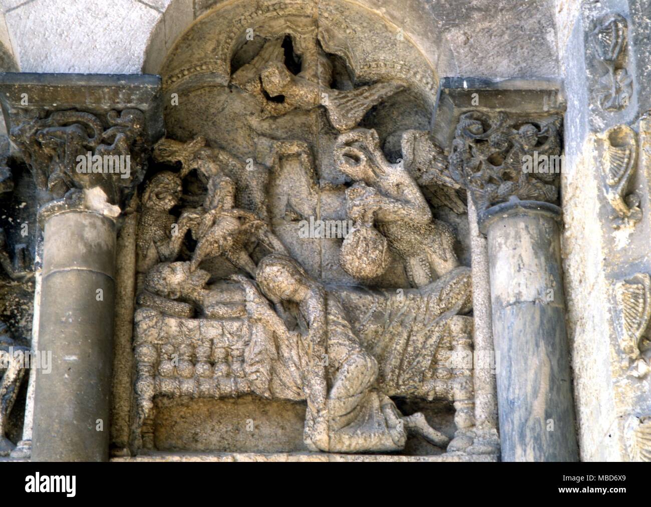 Marble relief - demons around a deathbed. From the porch of St Pierre, Moissac, France Stock Photo