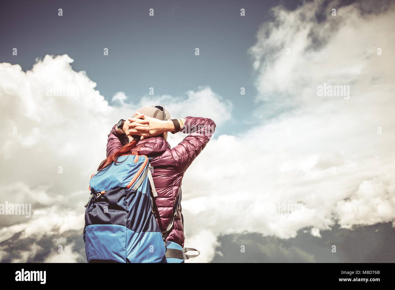 Toned image from back of girl with hands behind head Stock Photo