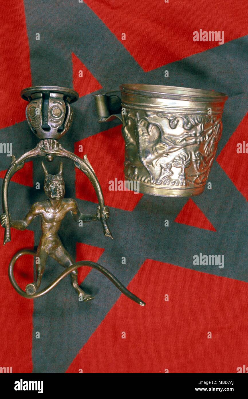 Various ritual objects used in the practice of the Black Mass. The pentacle flag, the oblation tankard and the magical candlestick. Stock Photo