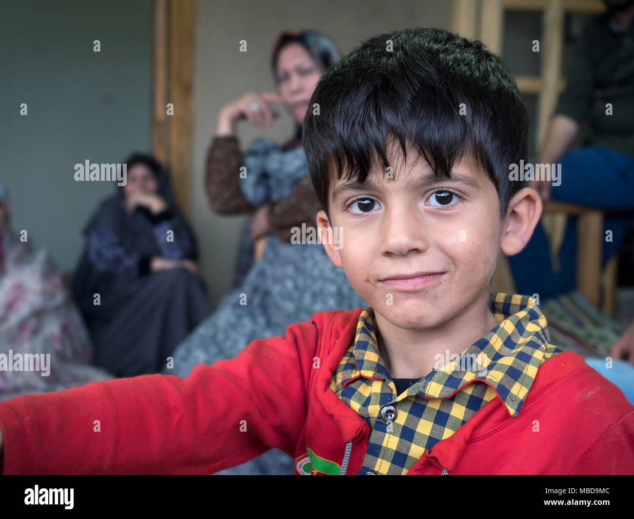 Kang, Iran - July 30, 2016 : portrait of an iranian child with his family in background Stock Photo