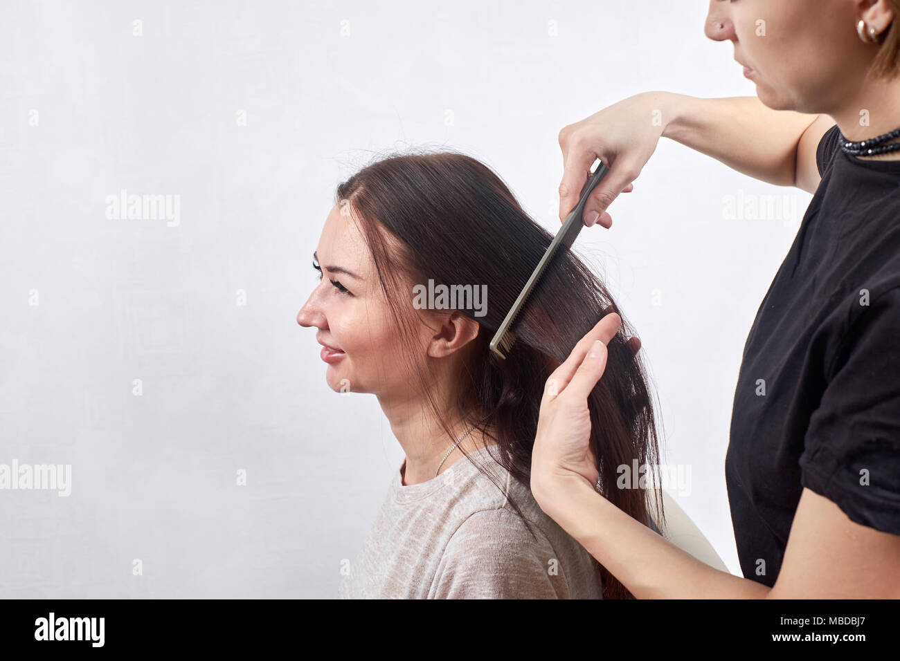 hair stylist making new haircut to brunette woman in salon Stock Photo