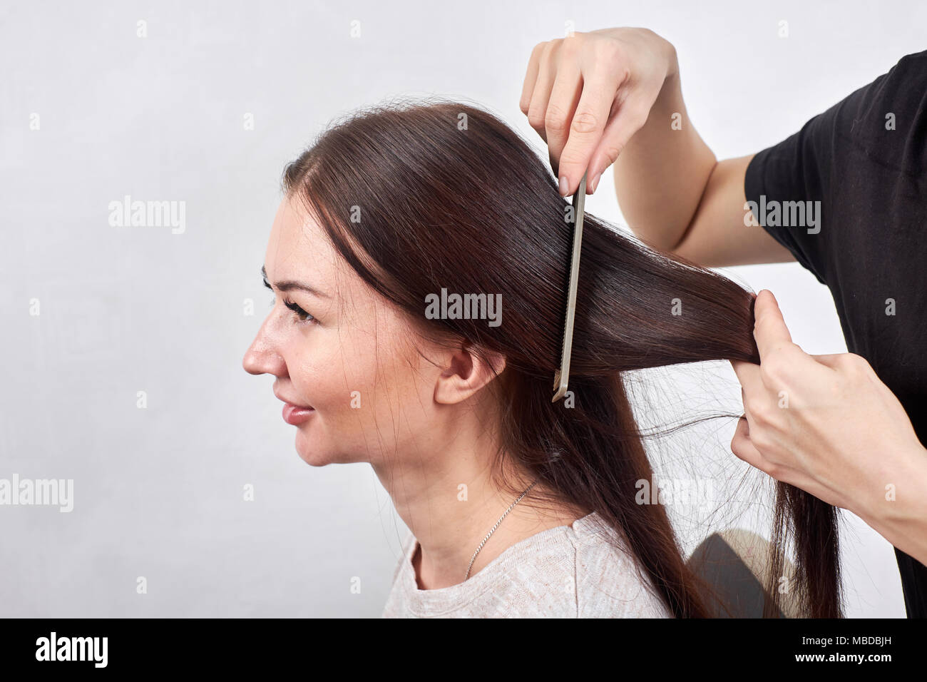Closeup Of Hair Stylist Combing Client S Hair In Salon Stock Photo