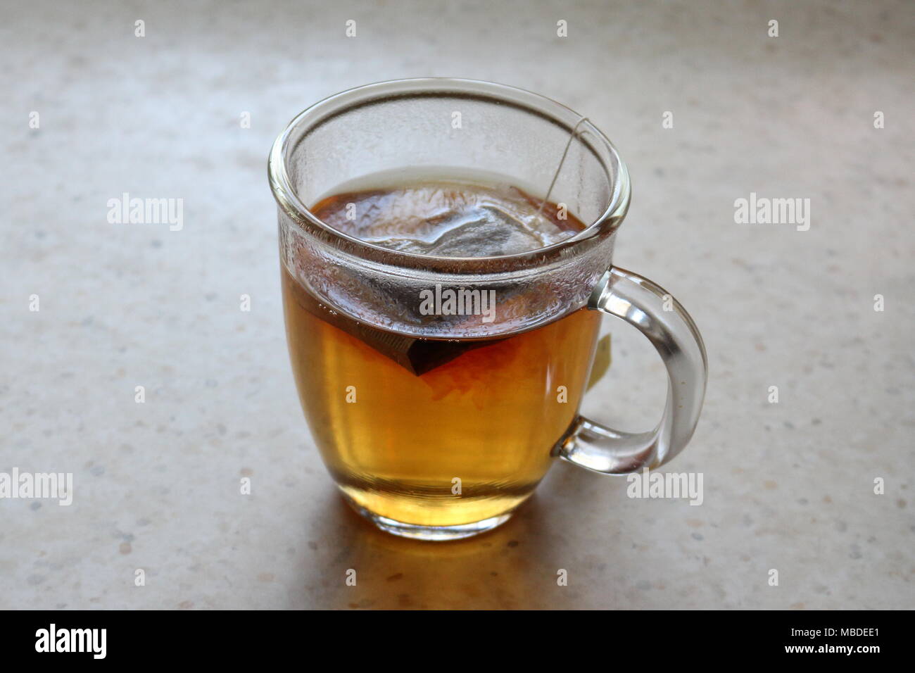 Teabag in a glass cup of hot water Stock Photo