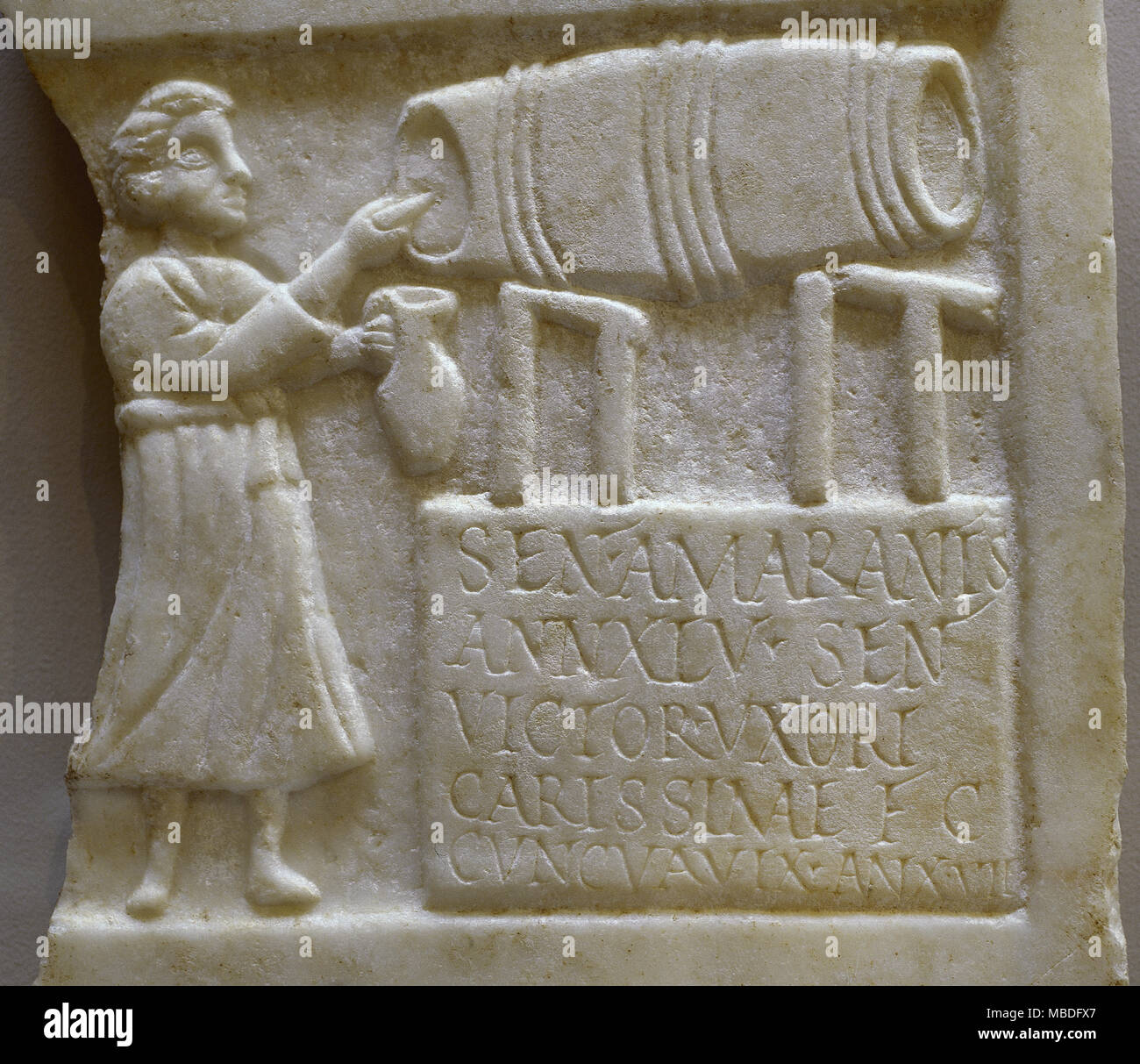 Funerary stele of Sentia Amarantis. The figure of the innkeeper appears filling a jug with wine from a barrel. In the inscription, the husband dedicates the tombstone to the deceased. 2nd-3rd century AD. Marble. National Museum of Roman Art. Merida, province of Badajoz, Extremadura, Spain. Stock Photo