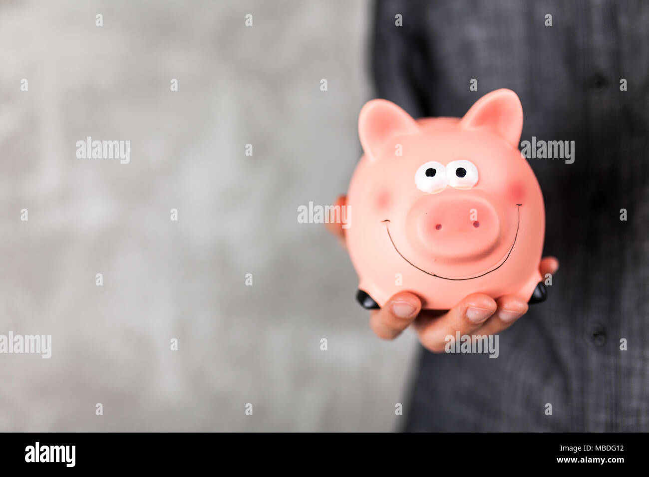Man holding a piggy bank Stock Photo - Alamy