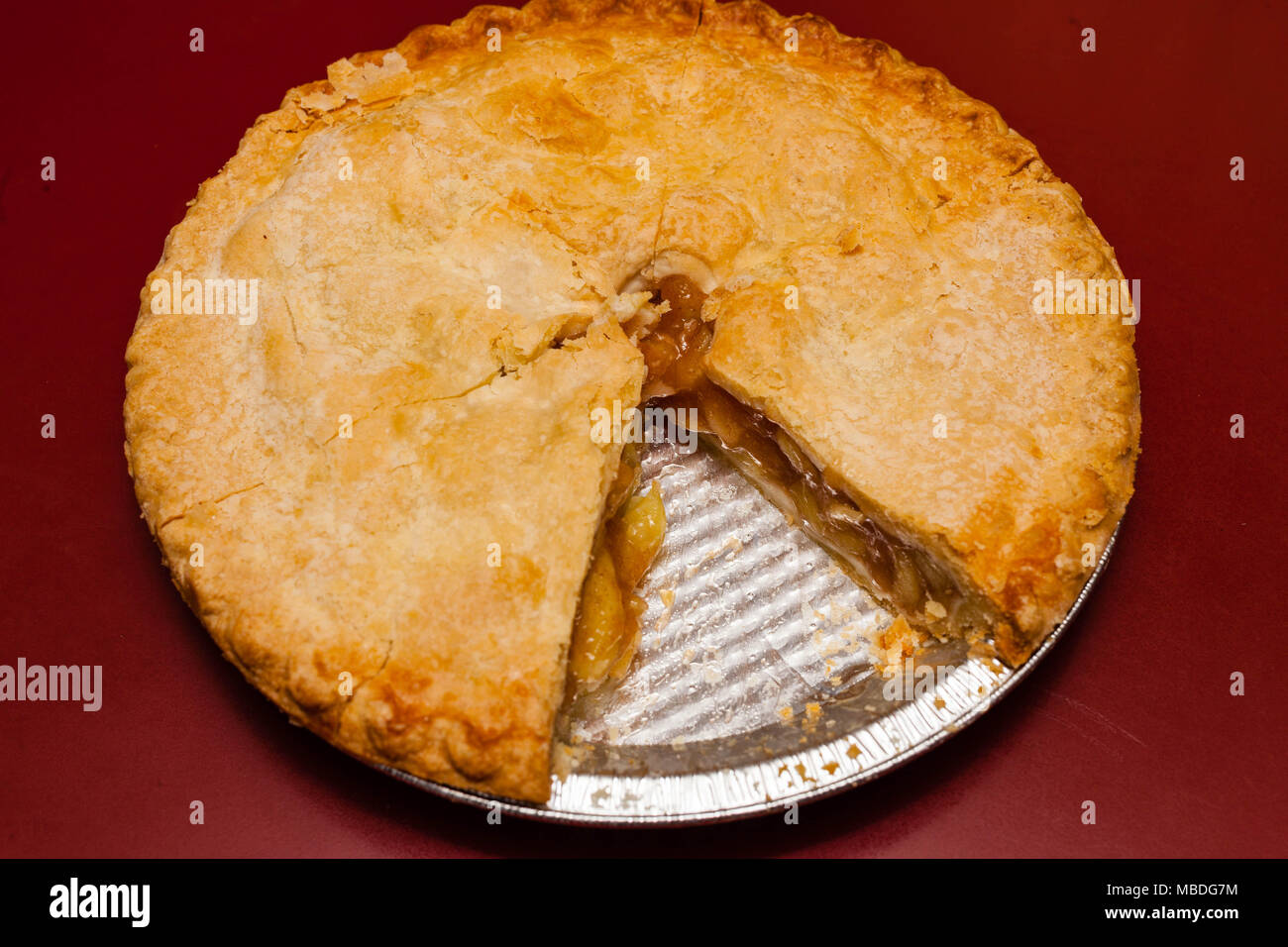 An Apple pie with one piece missing overhead view Stock Photo