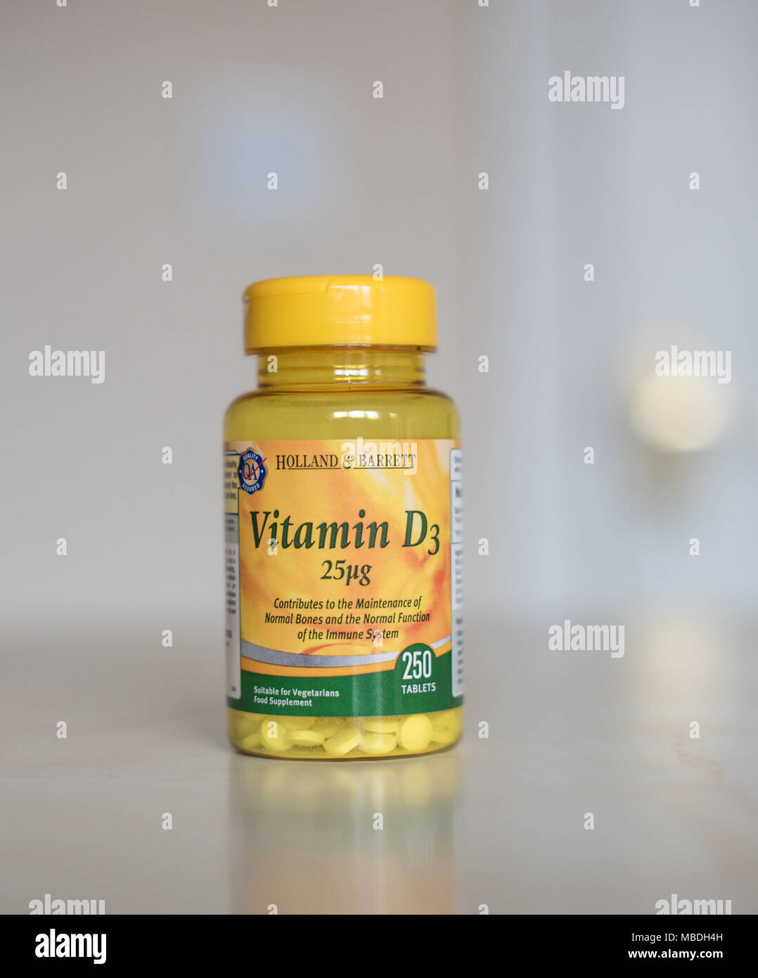 Vitamin D supplements in a clear bottle full of little tablets to make you feel better Stock Photo