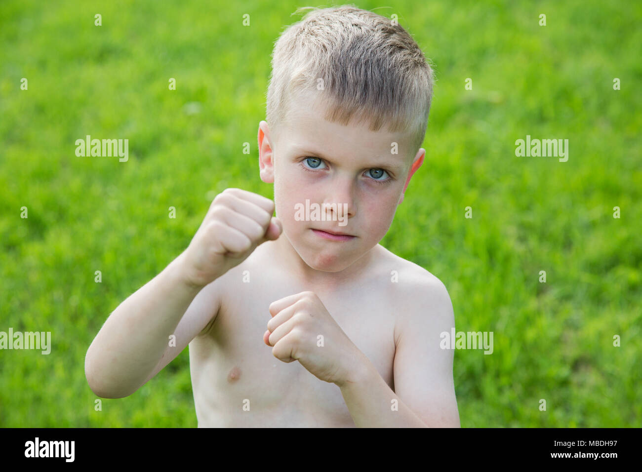 little boy boxing on the lawn on a summer day Stock Photo