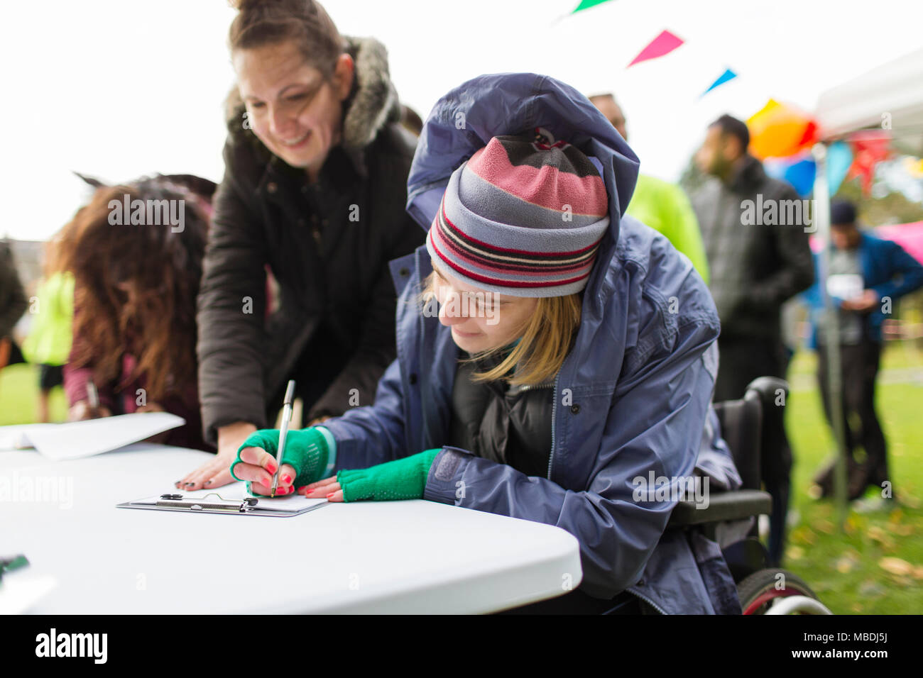 Woman in wheelchair checking in at charity race Stock Photo