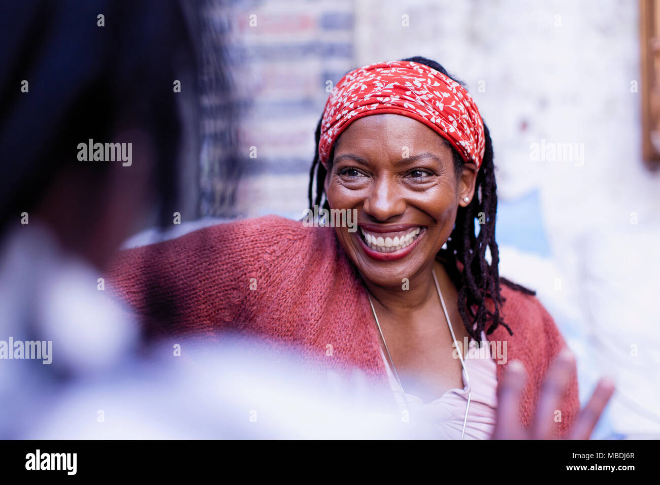 Enthusiastic, smiling woman listening to friend Stock Photo