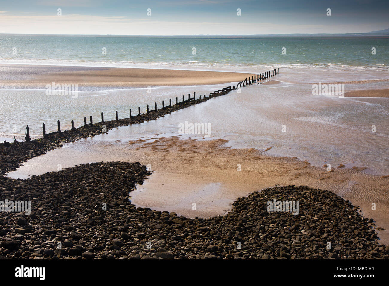 Remote ocean beach with craggy jetty, Heysham, Lancs, UK Stock Photo