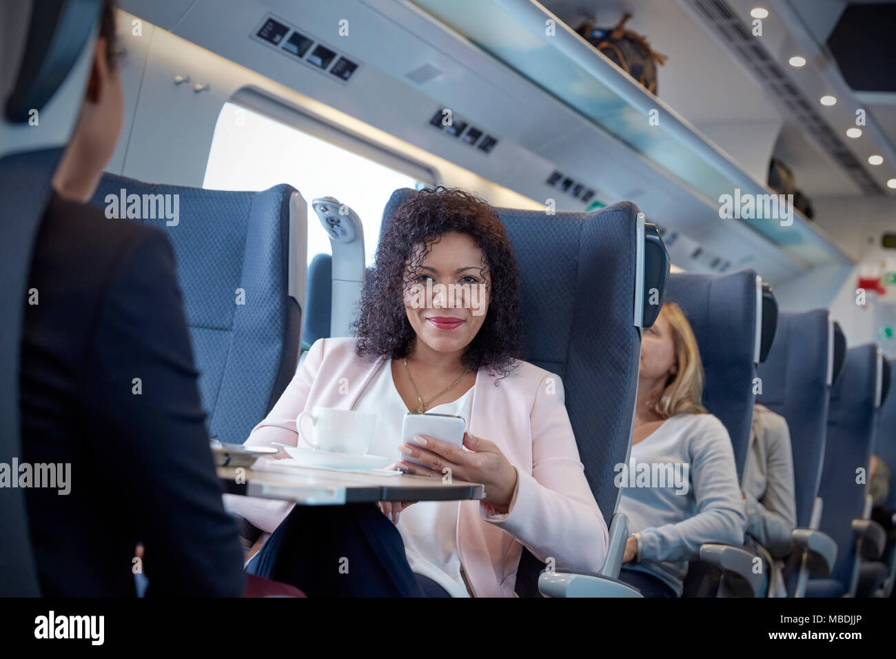 Portrait smiling, confident businesswoman using smart phone on passenger train Stock Photo