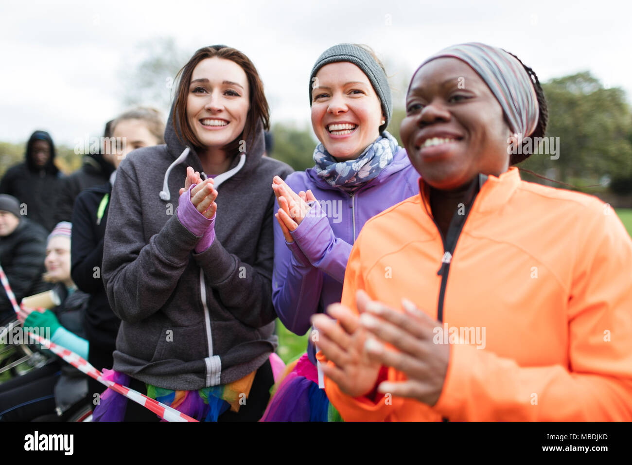 Female spectators clapping at charity run Stock Photo