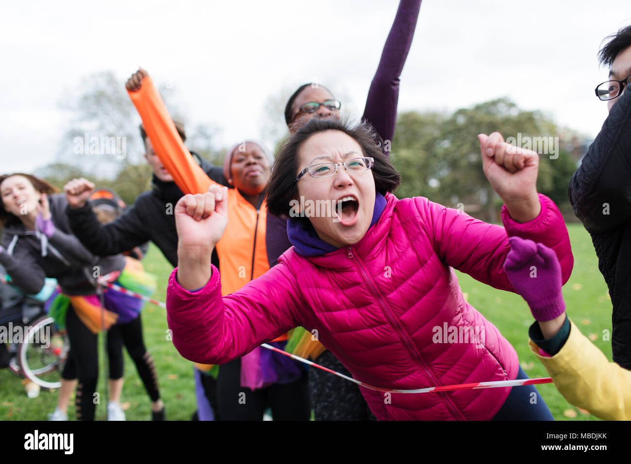 Enthusiastic female spectator cheering at charity run in park Stock Photo