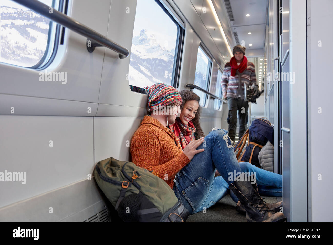 Young couple backpacking, riding passenger train Stock Photo