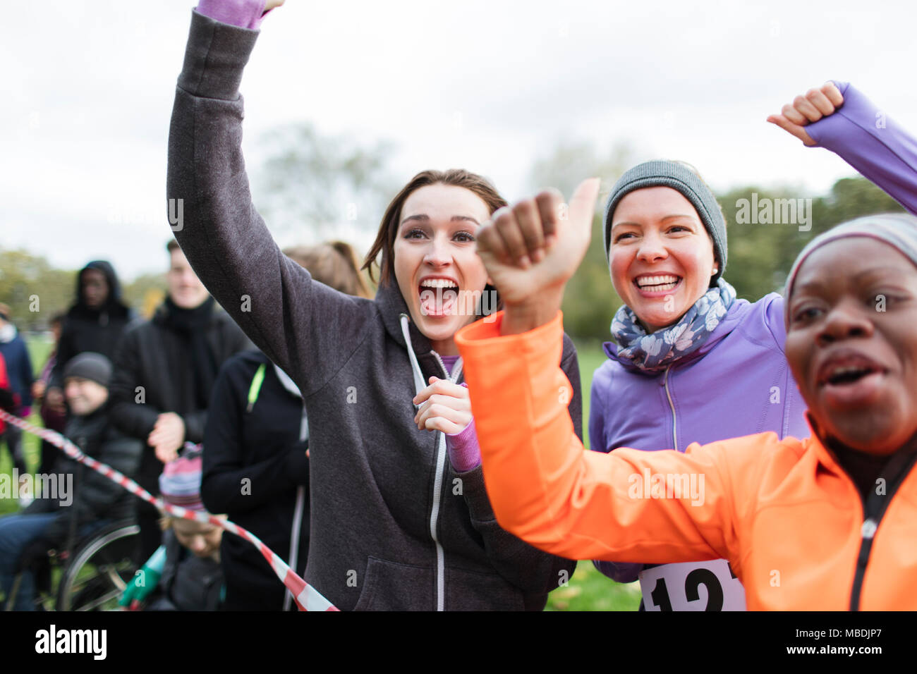 Enthusiastic female spectators cheering at charity run Stock Photo