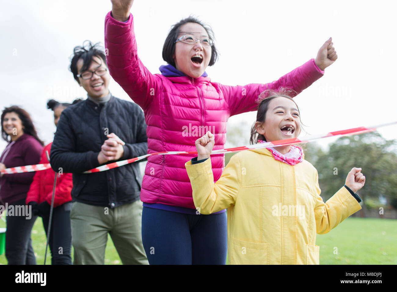 Enthusiastic family spectators cheering at charity run Stock Photo