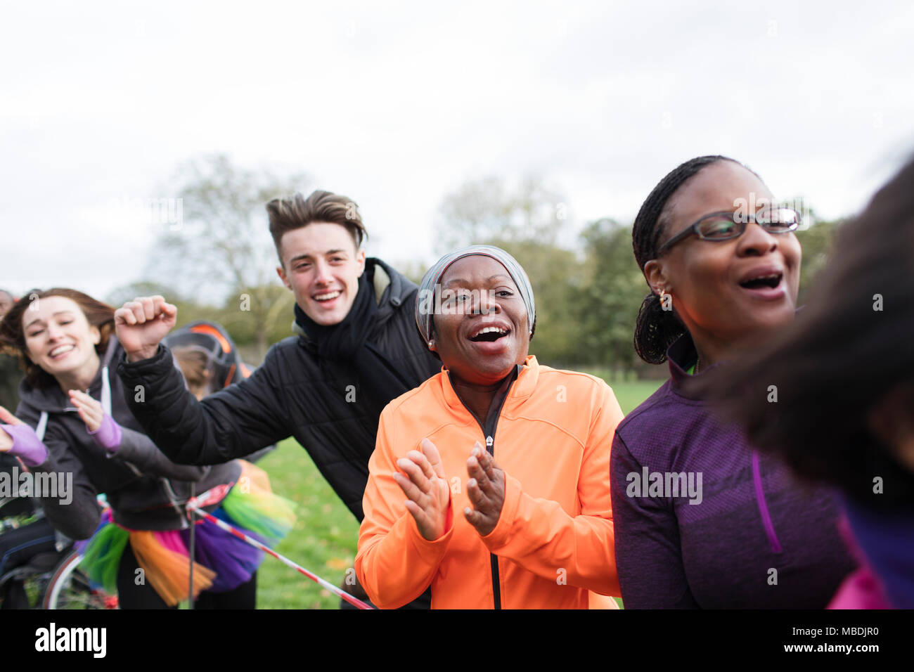 Enthusiastic spectators cheering at charity run in park Stock Photo