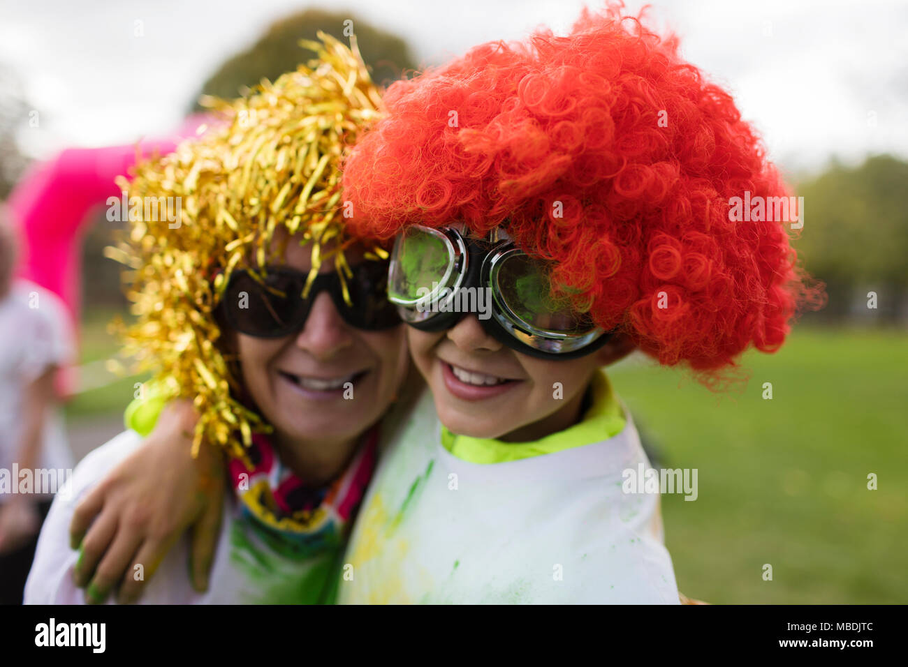 Portrait playful mother and son wearing wigs and goggles Stock Photo