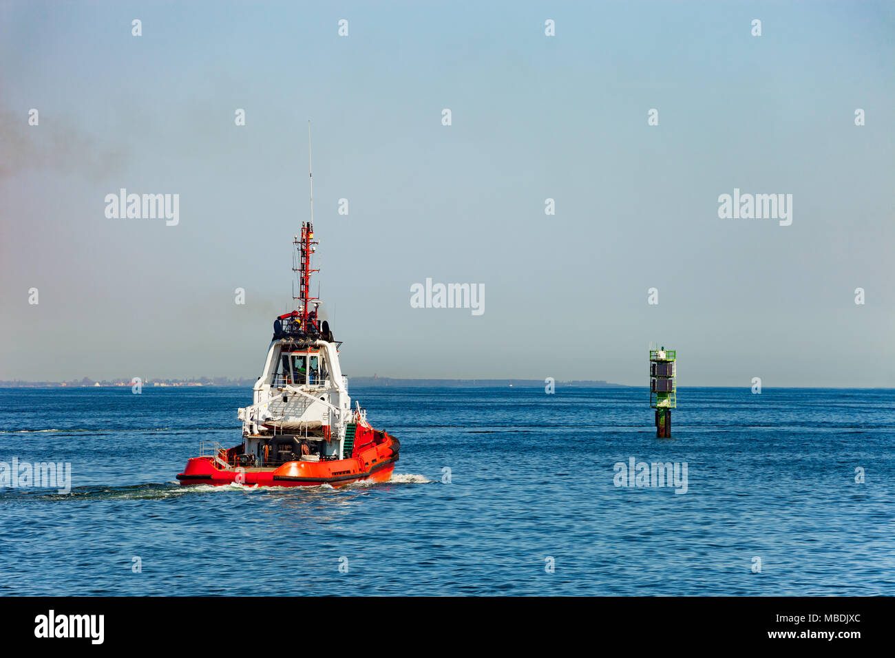 Tugboat and navigation mark on the shipping lane. Stock Photo