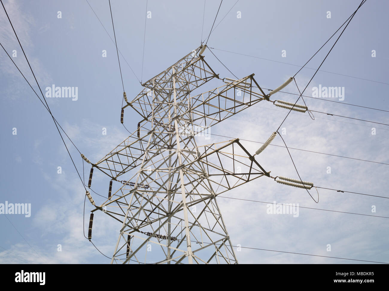 Electricity pylons and cables with blue sky and clouds in background ...