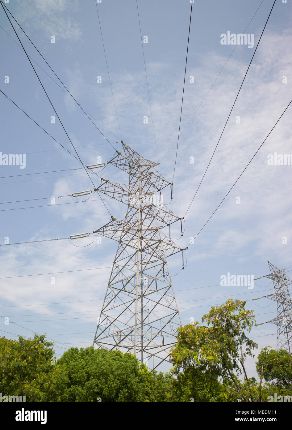 Electricity pylons and cables with blue sky and clouds in background ...
