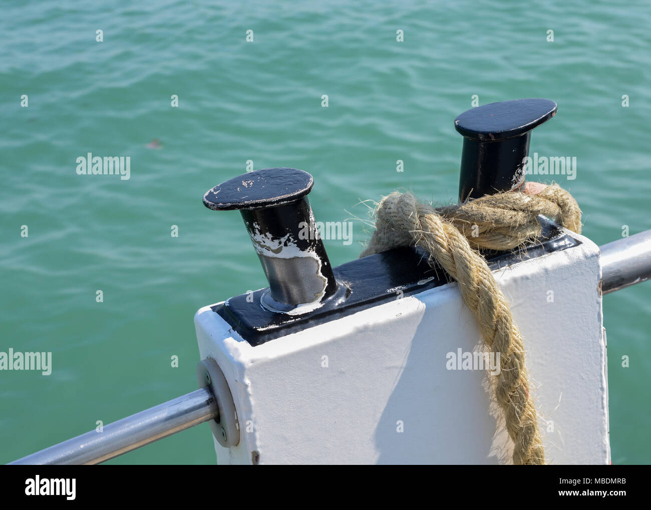 Close-up nautical knot rope tied around stake on boat or ship boat mooring rope. Stock Photo