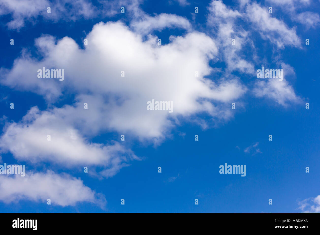 Blue sky with whispy fluffy cumulus clouds Stock Photo