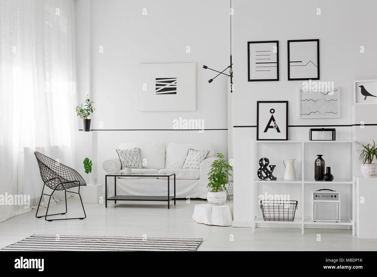 Table between black armchair and white sofa in spacious living room