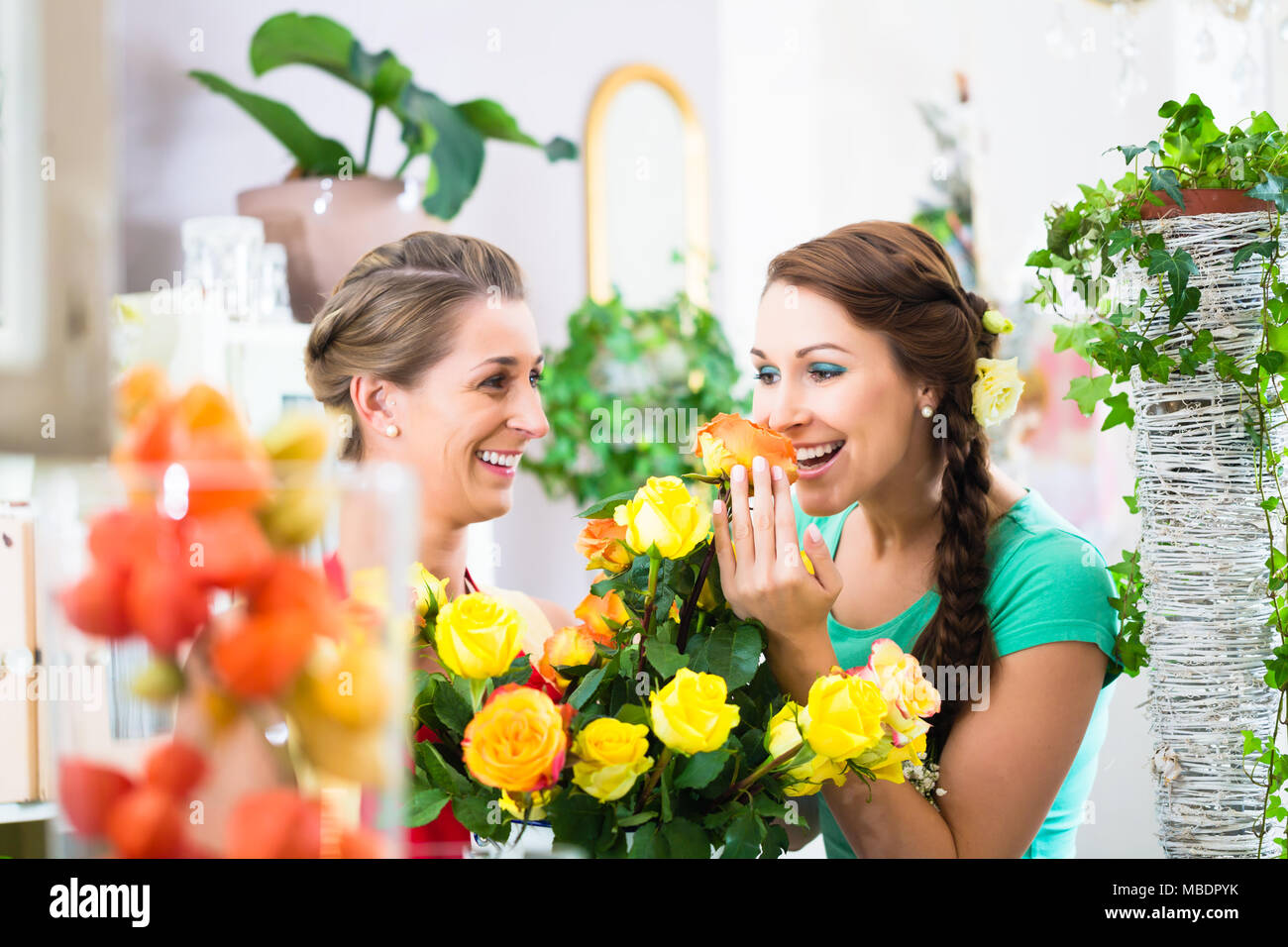 Women in flower store enjoying the roses Stock Photo