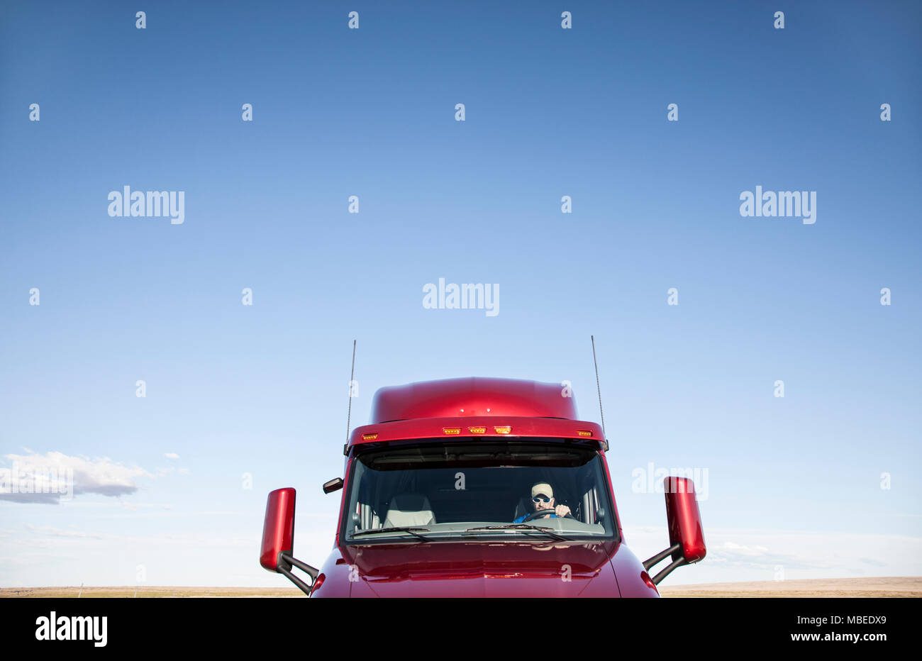 View of a Caucasian woman driver in the cab of her  commercial truck. Stock Photo