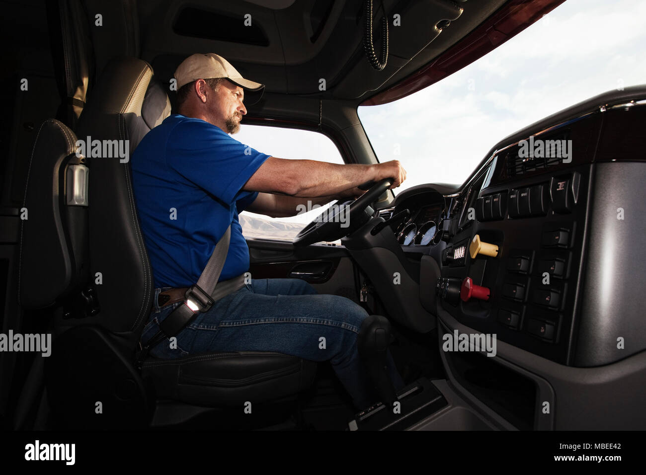 Caucasian man driver in the cab of a  commercial truck. Stock Photo
