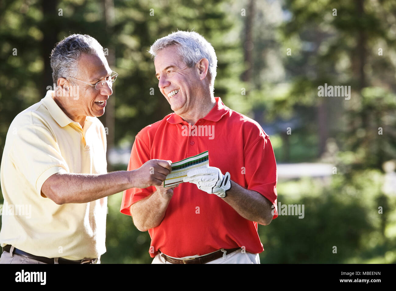 Two senior friends laughing about a golf score on a local golf course. Stock Photo