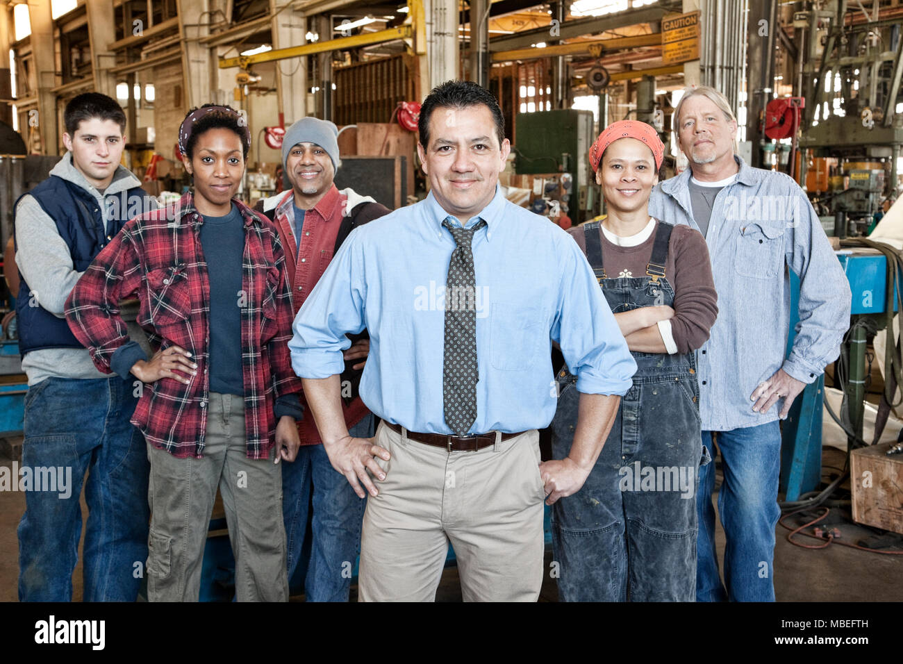 A group of 6 people, workforce workers at a factory, mixed ages and mixed ethnicities, ethnic diversity, women and men. Stock Photo