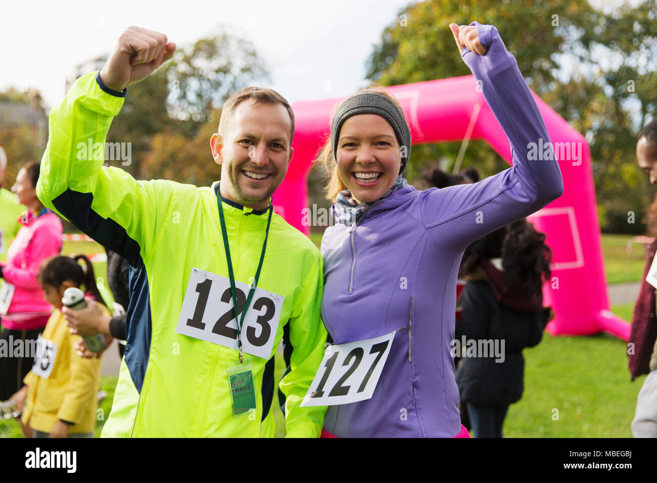 Enthusiastic runner couple cheering at charity run in park Stock Photo