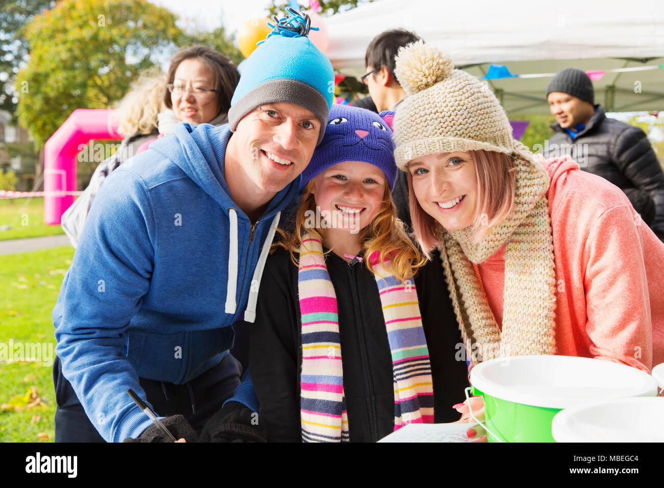 Portrait smiling, confident family at charity event in park Stock Photo