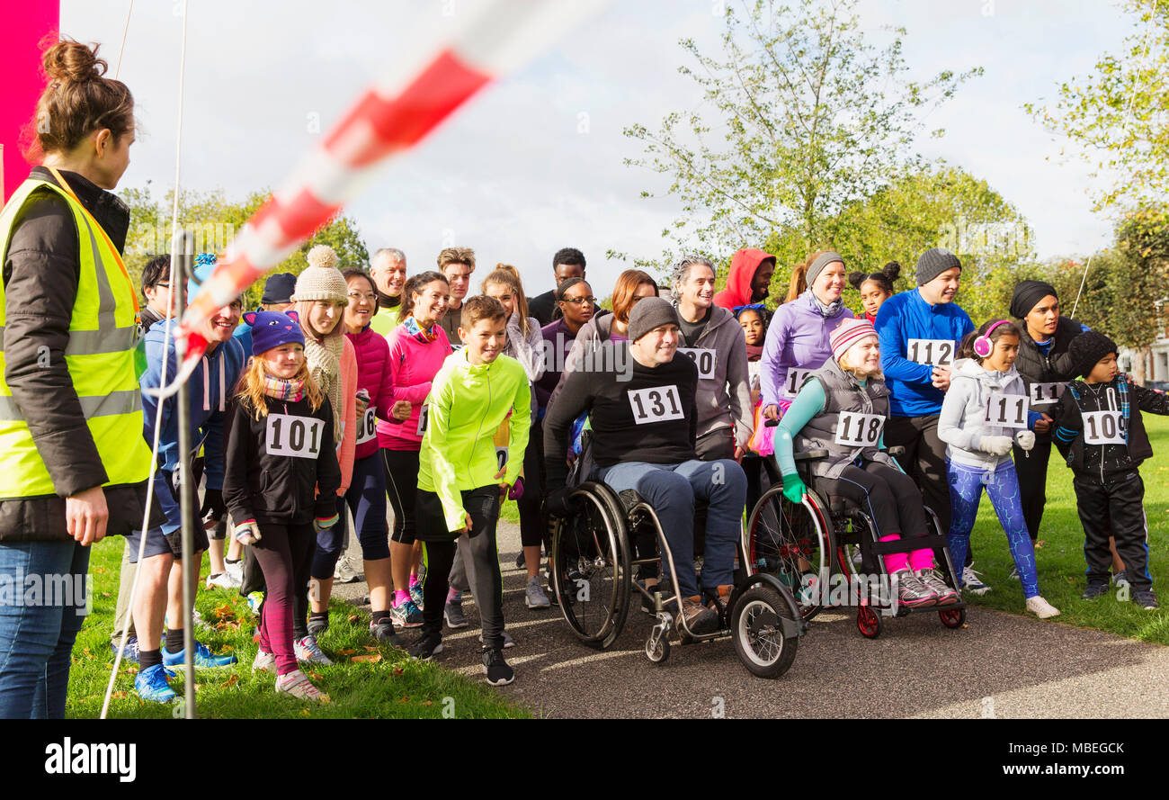 Crowd of runners and people in wheelchairs waiting at charity race starting line Stock Photo
