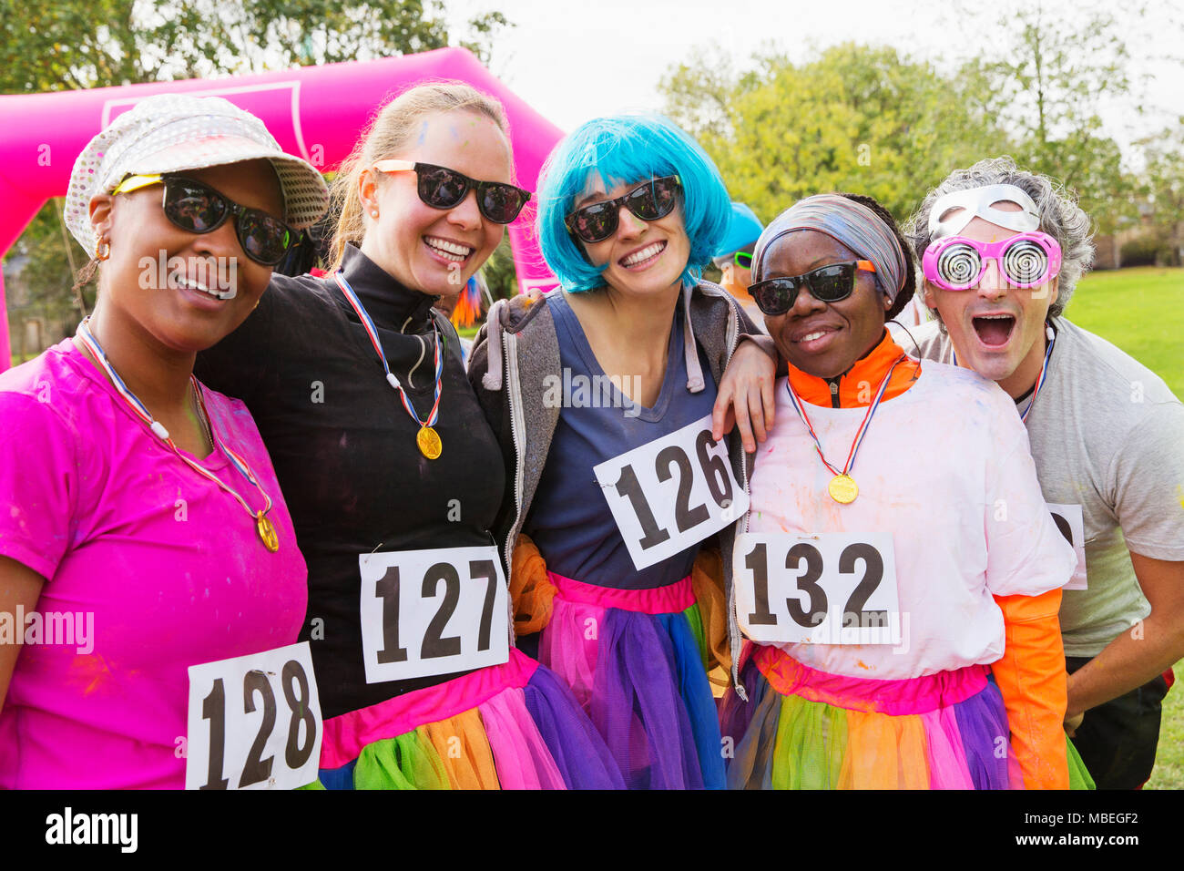 Portrait smiling, playful runner friends at charity run in park Stock Photo