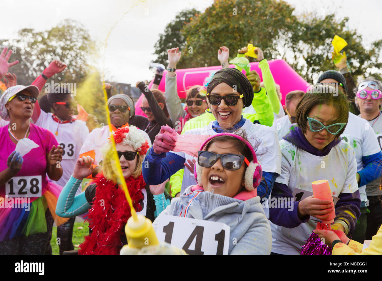 Portrait playful runners with holi powder at charity run in park Stock Photo