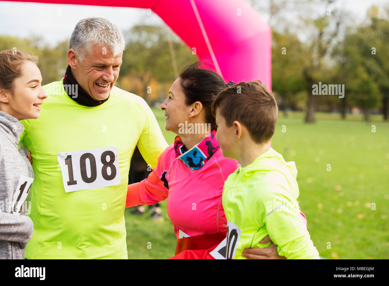 Happy family hugging at charity run in park Stock Photo