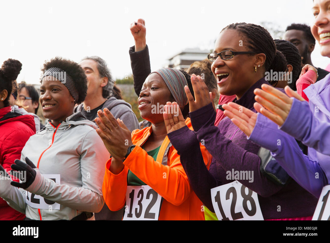 Marathon runners clapping, cheering Stock Photo