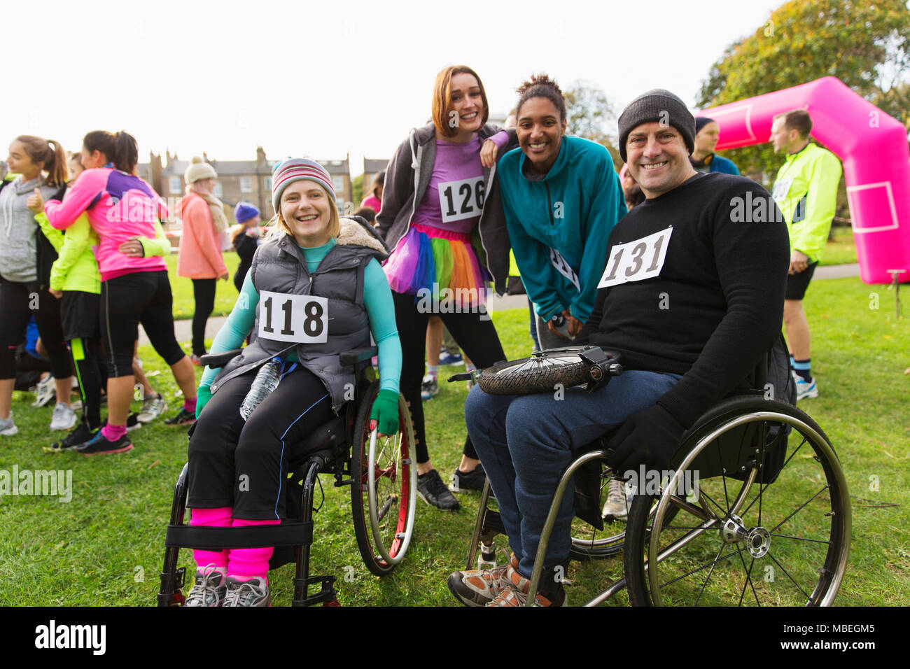 Portrait smiling friends in wheelchairs at charity race in park Stock Photo