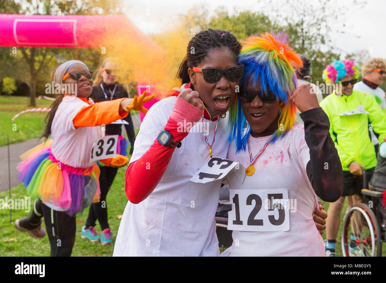 Portrait confident, enthusiastic female runners cheering at charity run in park Stock Photo