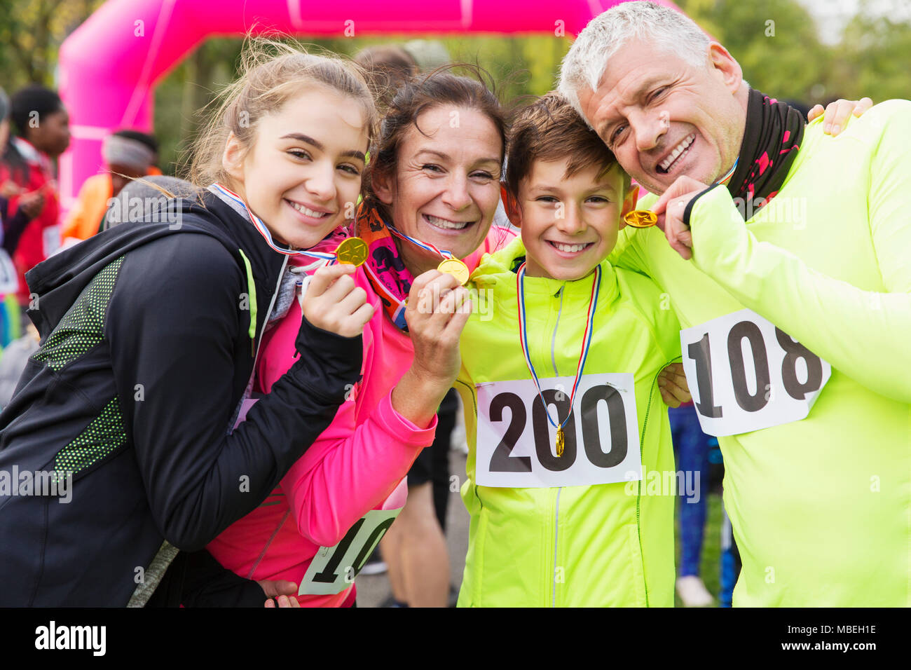 Portrait smiling, confident family runners showing medals at charity run Stock Photo