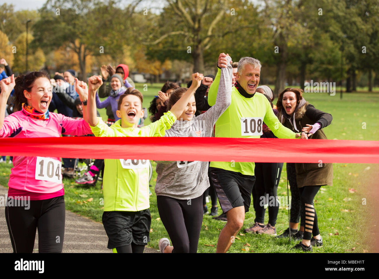 Enthusiastic family running, nearing charity run finish line Stock Photo