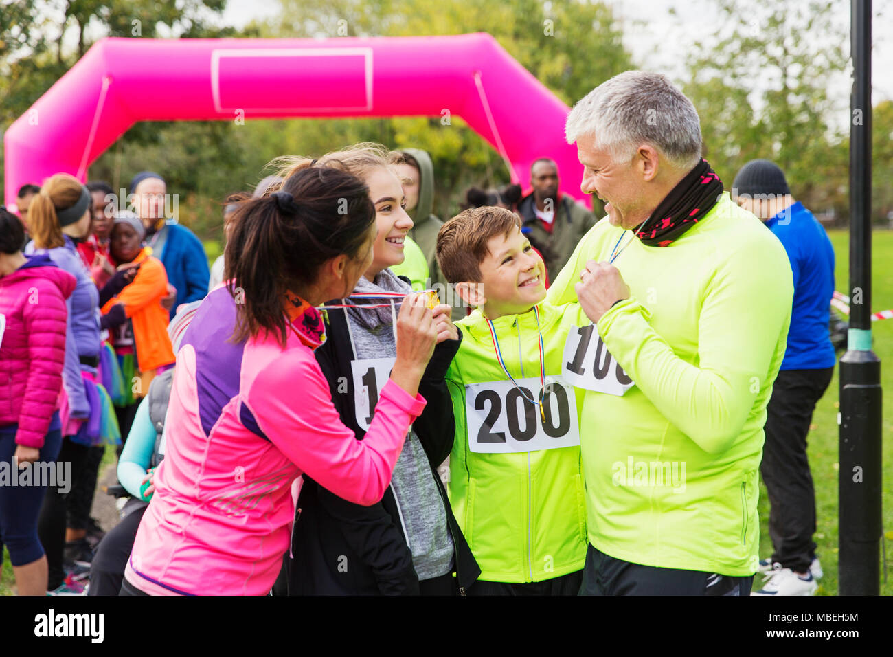 Happy family with medals finishing charity run, celebrating Stock Photo