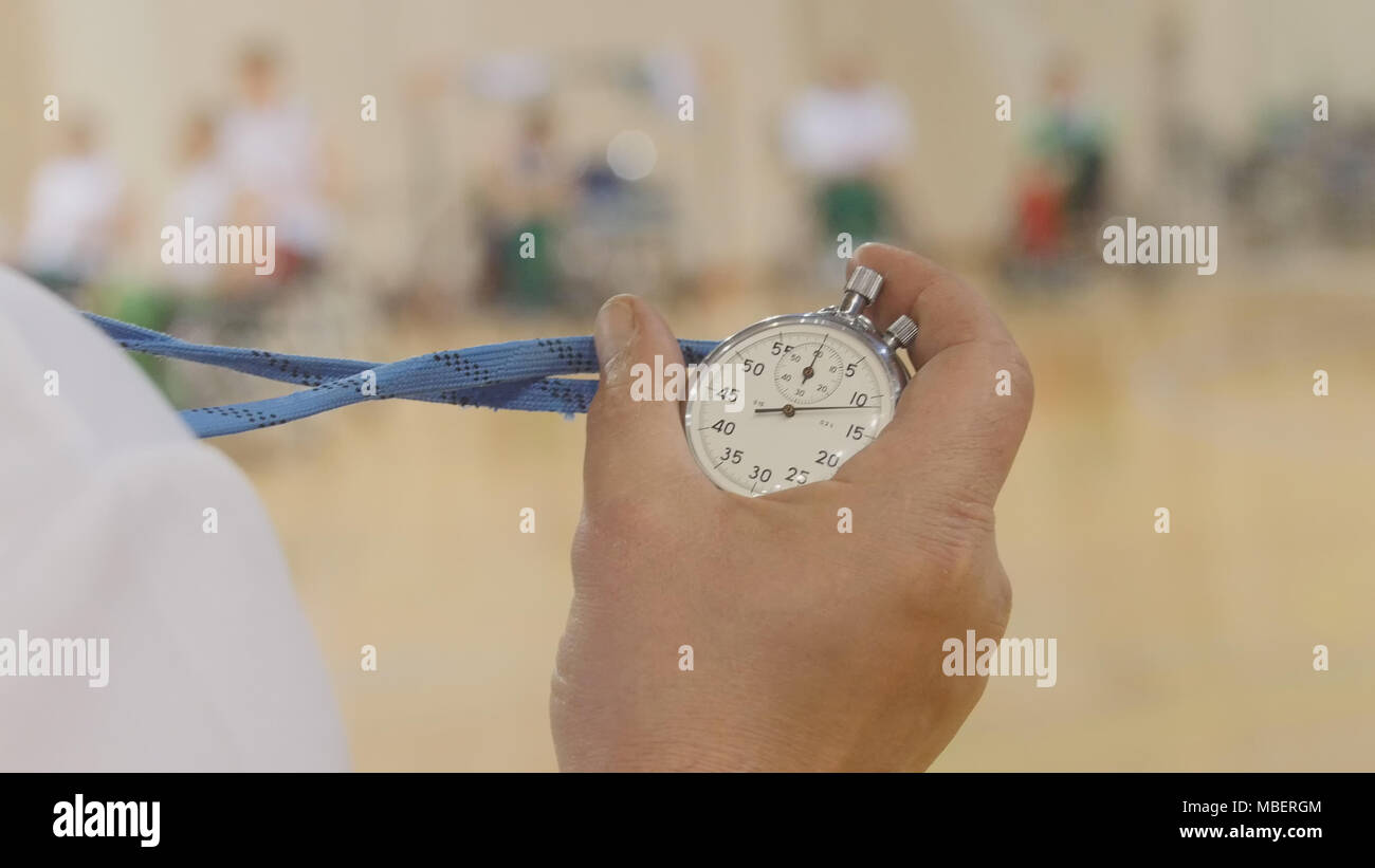 Stopwatch in hand of coach during training for wheelchair basketball