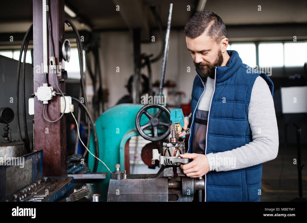 Mature man mechanic repairing a car in a garage Stock Photo - Alamy